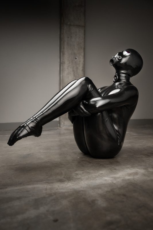 A sexy photograph of Charlee in black latex. Tagged with: gasmask & toe socks. Posted July 2021.