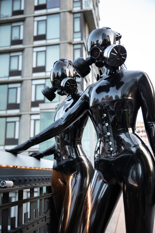 A sexy photograph of Vespa & Cam Damage, in black latex. Tagged with: in public & gasmask. Posted November 2019.