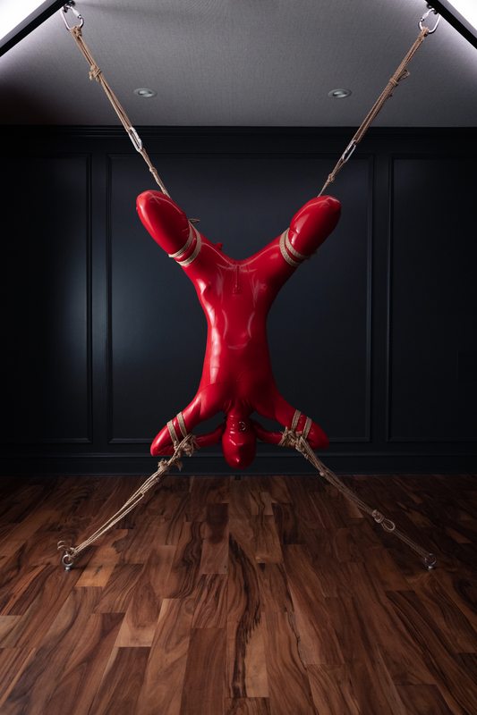 A sexy photograph of Vespa & Knotty Devil in red latex. Tagged with: rope / shibari. Posted October 2022.