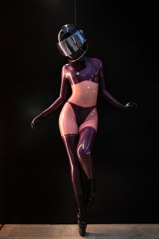 A sexy photograph of Defiantly Yours, in purple & pink & transparent latex. Tagged with: in public & moto helmet. Posted January 2020.