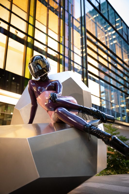 A sexy photograph of Defiantly Yours in purple & pink & transparent latex. Tagged with: in public & moto helmet. Posted January 2020.