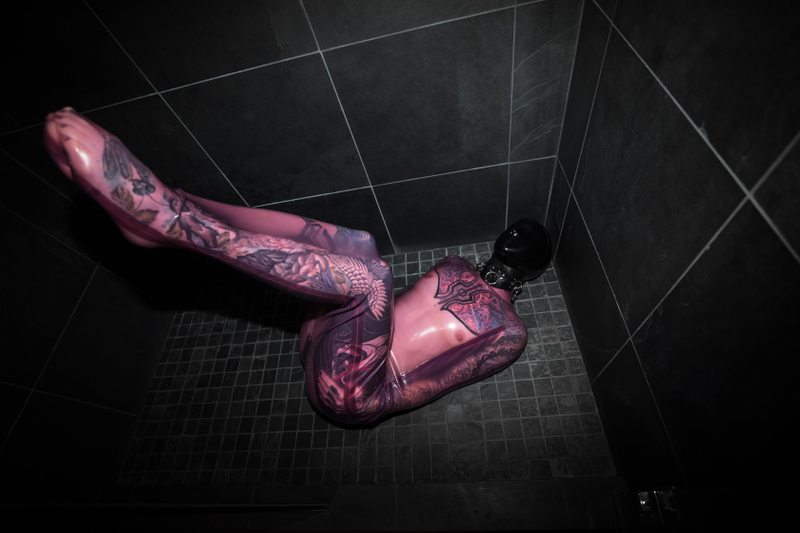 A sexy photograph of Fire Rabbit in transparent & purple & pink latex. Tagged with: tattoos & sleepsack. Posted December 2017.