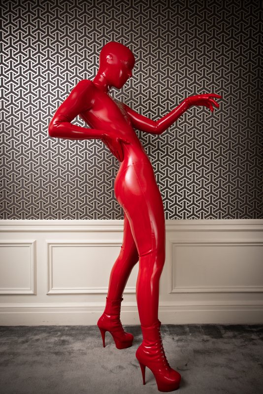 A sexy photograph of Cam Damage in red latex. Posted April 2021.