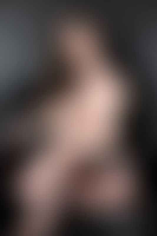 A sexy photograph of Vauntastic showing bare skin with black latex. Posted July 2023.