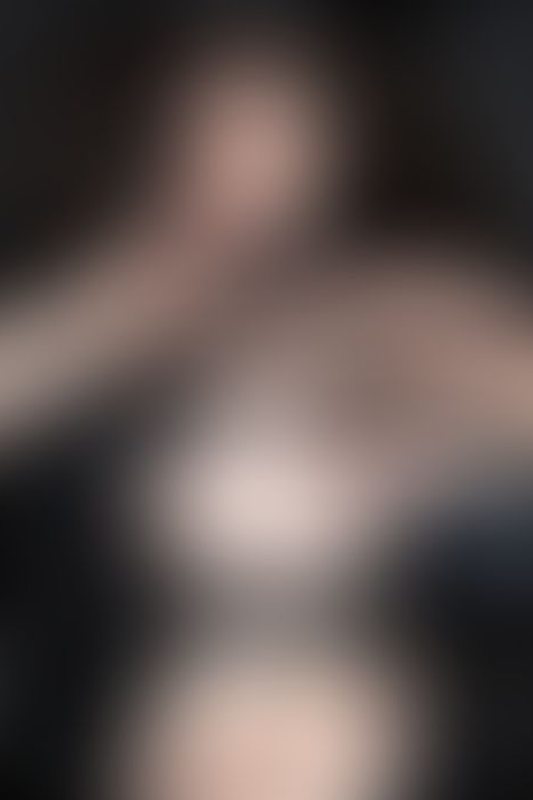 A sexy photograph of Vauntastic showing bare skin with black latex. Posted July 2023.