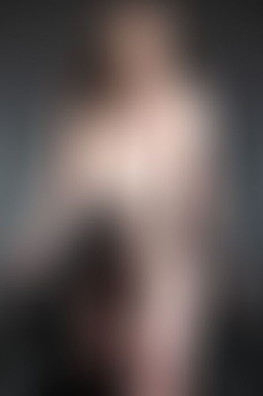 A sexy photograph of Vauntastic showing bare skin with black latex. Posted July 2023.