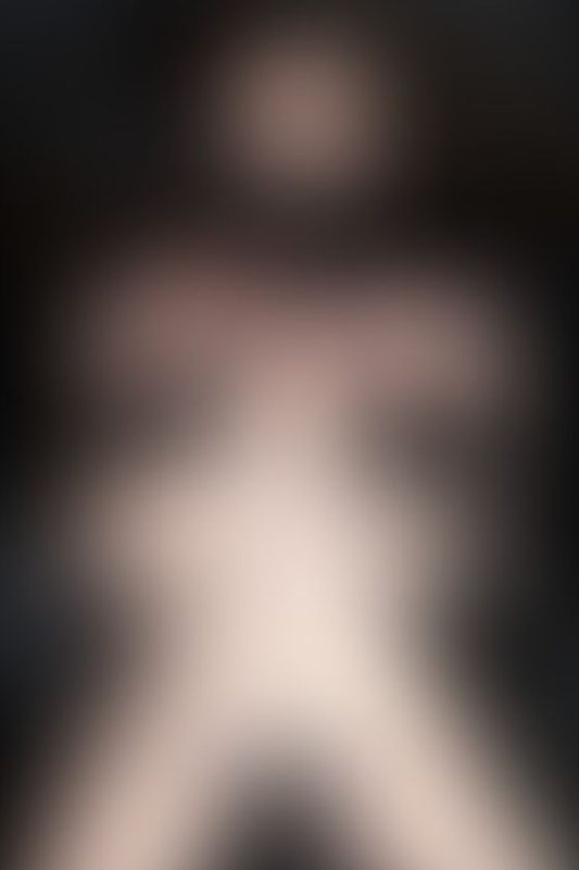 A sexy photograph of Vauntastic showing bare skin with black latex. Posted July 2023.