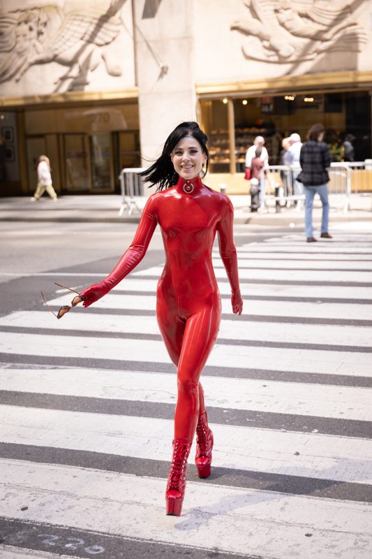 A sexy photograph of Awlivv in red latex. Tagged with: in public. Posted June 2025.