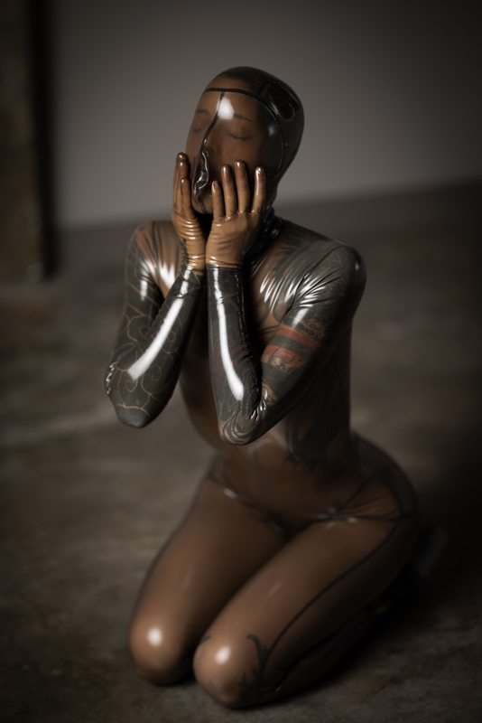 A sexy photograph of Cam Damage in transparent latex. Posted July 2021.