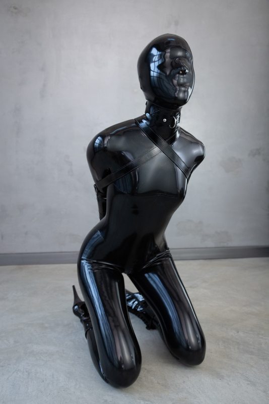A sexy photograph of Ravyn Alexa, in black latex. Tagged with: armbinder. Posted December 2021.